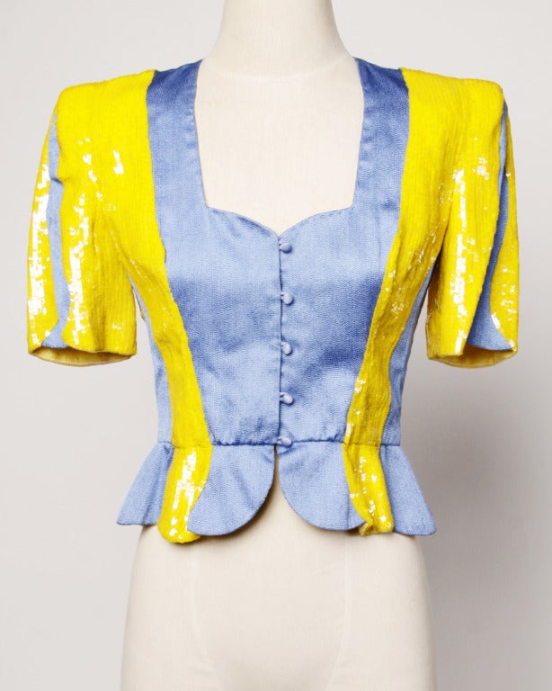 Carolina Herrera for Neiman Marcus two-tone bright yellow sequin and sky blue structured peplum jacket with short sleeves, bold shoulders, and a scalloped mini peplum. Organically shaped fabric-blocking contrasts nicely with the structured