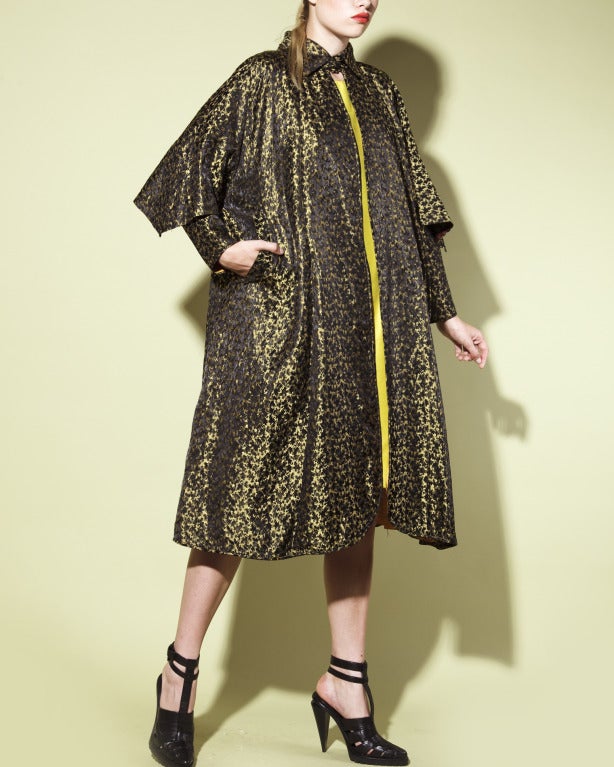 Unique vintage chartreuse and black avant garde swing coat in vibrant reflective jacquard fabric from the 1940's. Angular caped sleeves, pointed collar and full sweep. The coat is fully lined in mustard fabric and features side pockets and hook