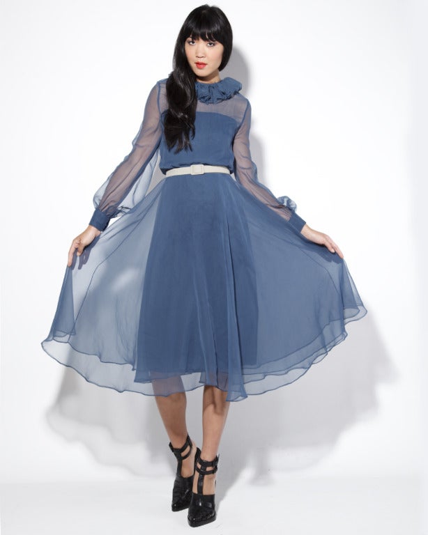 Gorgeous sheer washy Atlantic blue silk midi dress by Richilene for Elizabeth Arden. This dress features long sheer balloon sleeves, a ruffled collar and full sweep triple layered skirt. It is fully lined in silk with rear zip, hook and snap