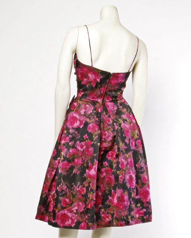 Vibrant pink and black silk satin party dress with a ruched bodice, spaghetti straps, and an asymmetrical side bow. Partially lined with metal zip closure.

DETAILS:

Partially lined
Back metal zip closure
Circa: 1960s
Estimated Size: