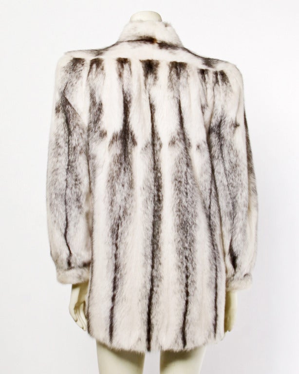 Plush black and white cross mink fur coat in excellent condition. Side pockets, front hook closure and black satin lining. A gorgeous piece!

Measurements:

Bust: Up to 40