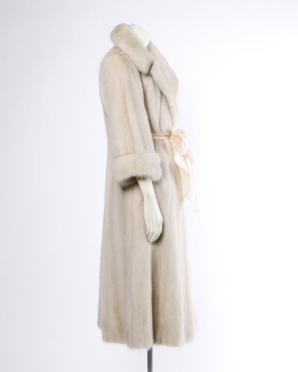 Plush blonde mink fur coat with a pop up collar and matching satin waist sash. Full pelts are soft and in perfect condition. Silk satin lining and long sleeves with cuffs.

Details

Fully lined
Front tie closure
Circa: 1970s
Estimated Size: