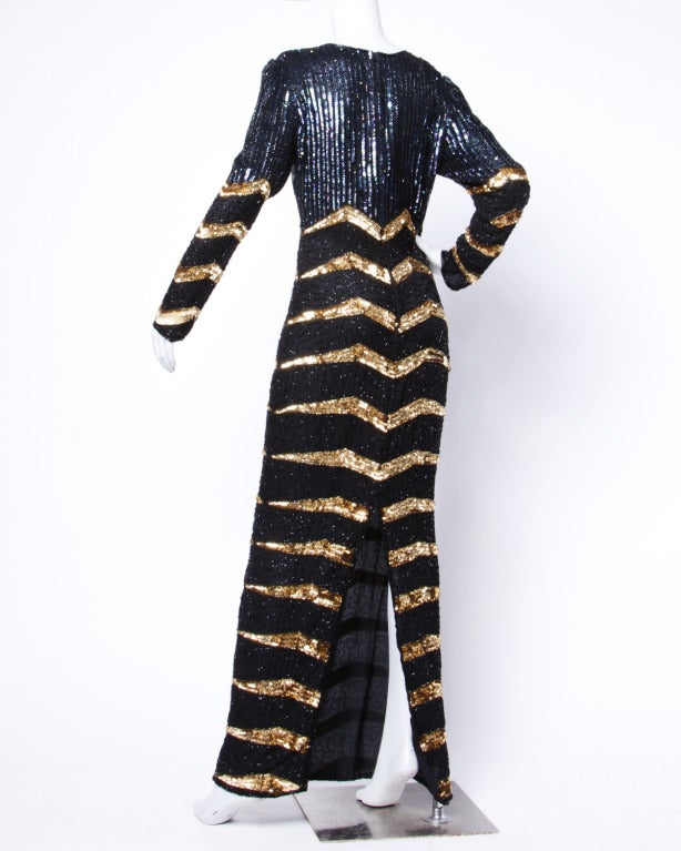 Gorgeous metallic gold and black silk gown with long sleeves and side slits. Zig zag chevron design.

Details

Fully Lined
Back Zip and Hook Closure
Circa: 1980s
Marked Size: M
Estimated Size: M
Colors: Black / Gold / Purple 
Fabric: 100%