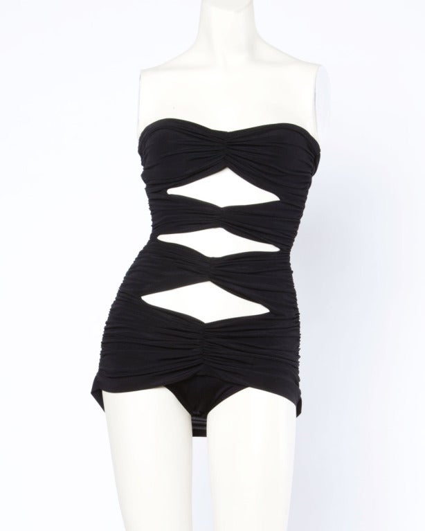 Iconic Norma Kamali Omo black cut out swim suit or body suit with triangular cut outs and strapless straps. 

Details

Partially lined
Fabric contains some stretch
Circa: 1980s
Estimated Size: S
Colors: Black
