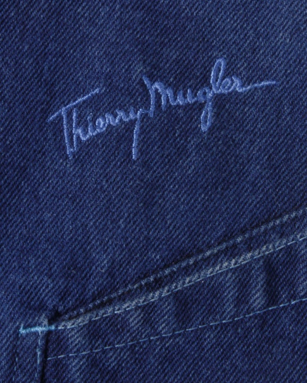 Dark denim jean skirt by Thierry Mugler. Snap front closure and embroidered logo on the back of the skirt.

Details

Unlined
Front snap button closure
Back pockets
Circa: 1980s
Label: Thierry Mugler
Marked Size: 42
Estimated Size: