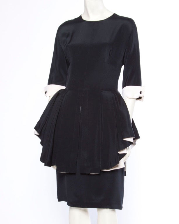 Extraordinary Bernard Perris black and white silk dress with a ruffled peplum and 3/4 length sleeves. Stunning couture construction with hand stitching on the silk interior. Rear zip closure and fully lined in silk. Made in France.

This is an