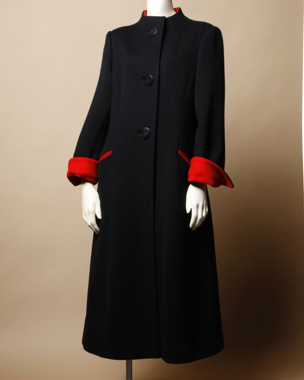 Black wool Trigere coat with stand up collar and red trim contrast lining. A beautiful coat with a strong silhouette. Fully lined. Front button and snap closure. Front pockets.

DETAILS:

Circa: 1980s
Label: Trigere
Marked Size: 14
Estimated