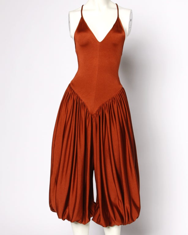 * Free shipping world wide.

This vintage harem jumpsuit by Norma Kamali just screams Studio 54. Open criss cross back and cropped harem pant legs. Unlined. Elastic waist. Pant ties at bottom. Fabric contains stretch. Highly collectible