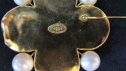 A costume Byzantine-style brooch of quatrefoil form designed as a gold-tone mount set with blue and green colored glass and imitation pearls