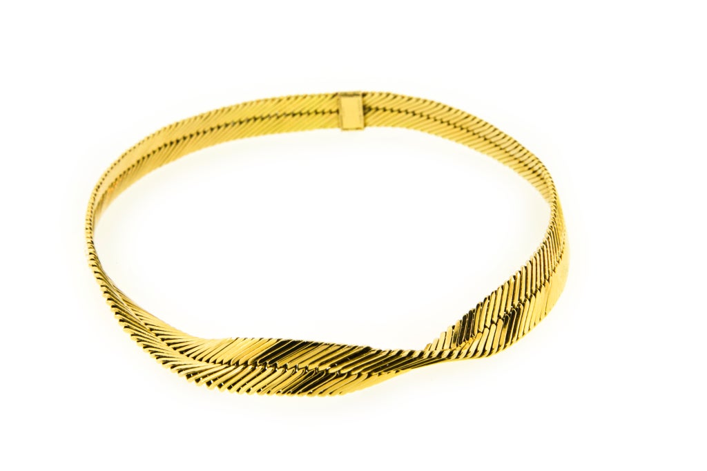 An 18kt gold collar necklace of flattened chevron links with a central twist