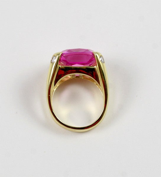 18kt Yellow Gold split shank dome ring with center 15mm Cushion Cut Pink Topaz (approximately 25cts) and four diamonds (approximately 0.40cts). 

Center Faceted Pink Topaz has an offset by the diamond accent stone. The elegant split shank add