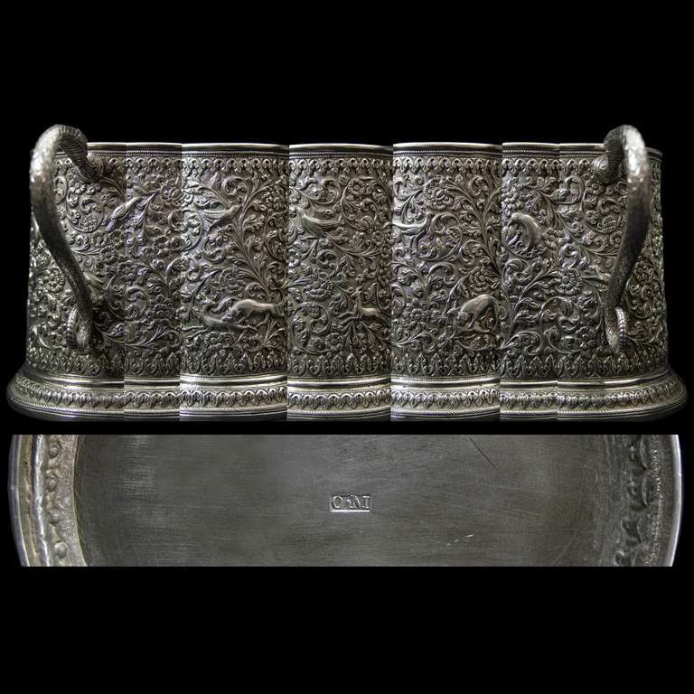 A very good silver tankard with a well modeled snake scroll handle. The tankard highly decorated with dramatic scenes of big cats engaged in hunting deer amongst luxurious foliage and exotic birds. 

Signed/Inscribed/Dated: Bhuj Circa 1900 by