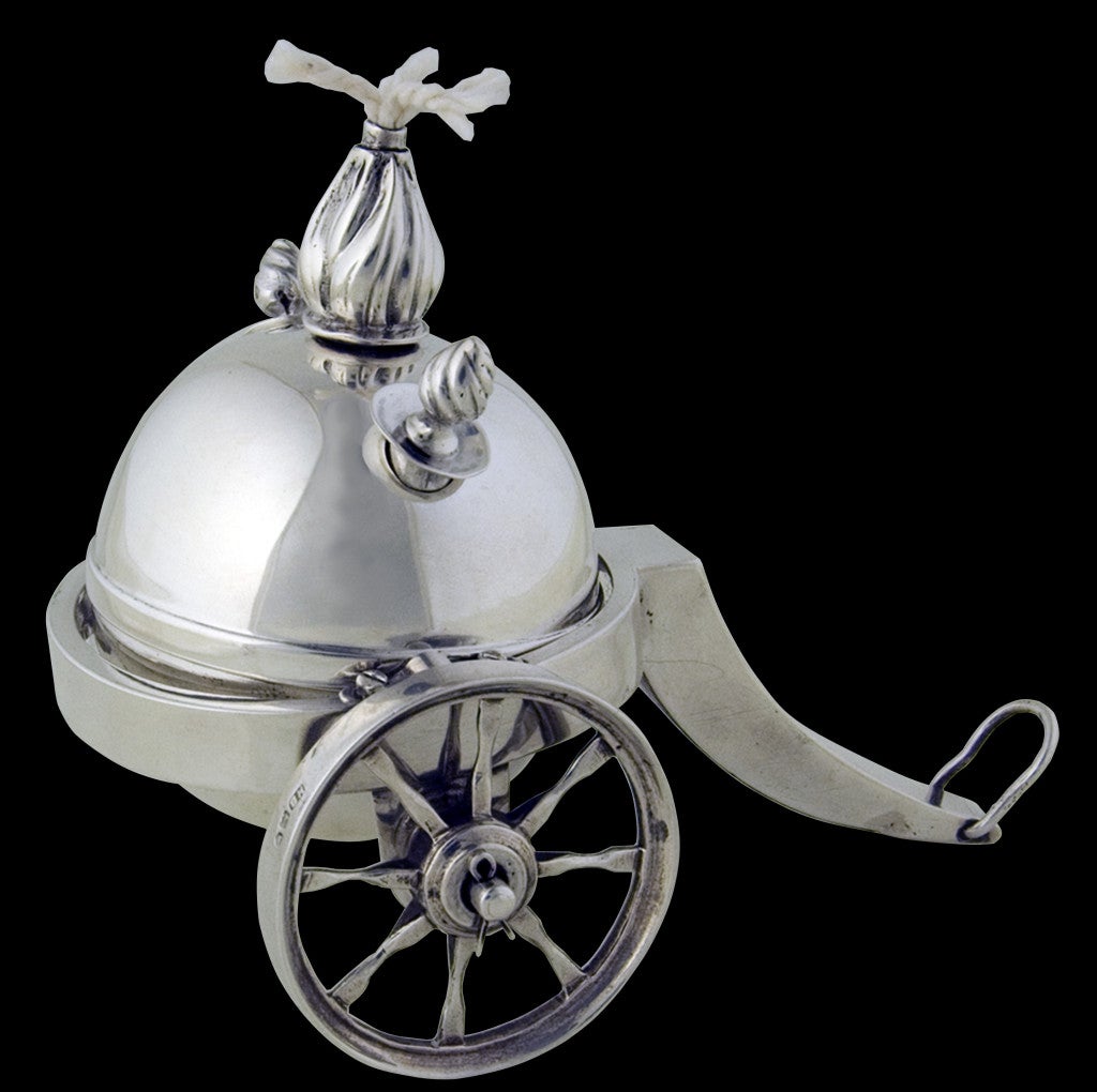 An unusual Edwardian novelty table lighter in the form of a bomb suspended by a gimble within a rolling gun carriage.