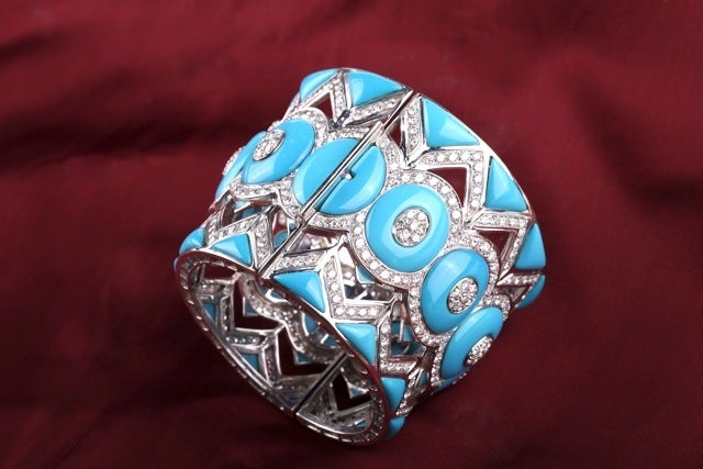 A powerful cuff bracelet manufactured in the USA during the 1980s, presenting a dynamic geometrical pattern composed of turquoise elements and fine quality brilliant cut diamonds weighing apprx. 25 cts total, on an 18kt white gold mounting.