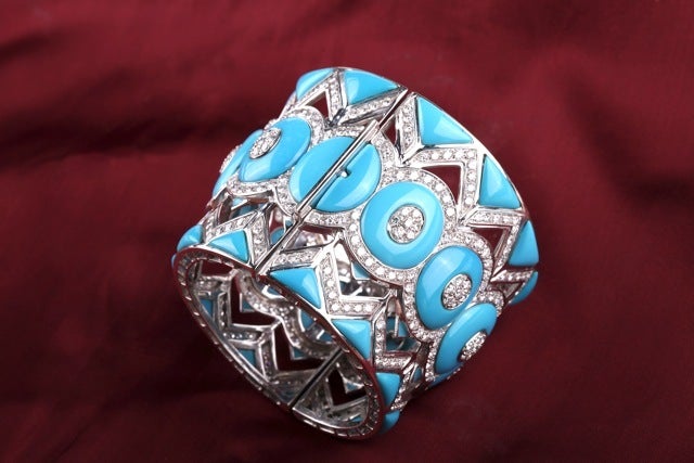 Ein kraftvolles Manschettenarmband, das in den 1980er Jahren in den USA hergestellt wurde und ein dynamisches, geometrisches Muster aus Türkiselementen und Diamanten im Brillantschliff mit einem Gesamtgewicht von ca. 25 ct auf einer Fassung aus 18kt