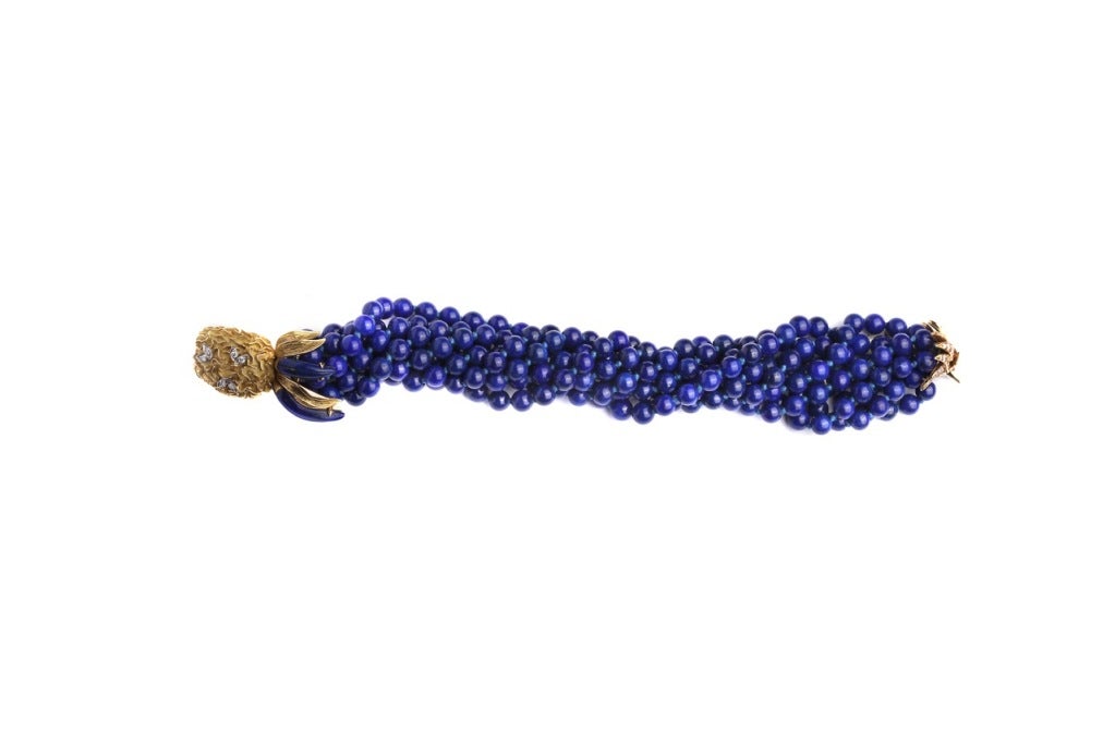 A sophisticated bracelet manufactured by Cartier during the 1970s, presenting several strands of very fine lapis lazuli spheres to be connected with decorative 18k yellow gold and diamond clasps.