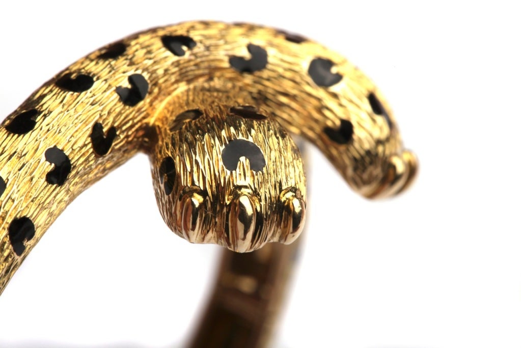 An 18kt yellow gold bracelet by French designer Fred, in the form of two crossing paws of a Leopard, presenting fine black enamel work to symbolise the animal's typical skin.