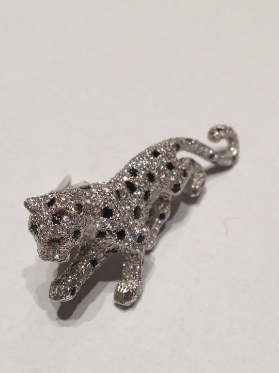 An incredible brooch by Cartier, representing the classic panther symbol, manufactured in Paris in the 1970s. The item presents brilliant cut diamonds and onyx, mounted in platinum.