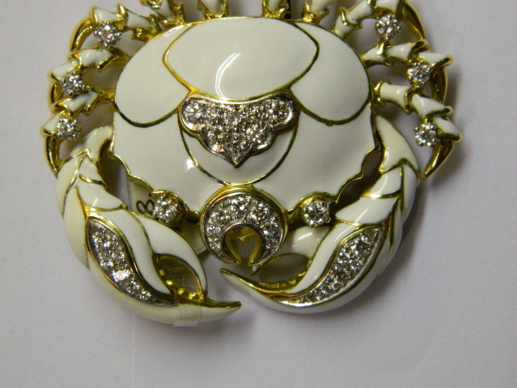 A stylish brooch, manufactured by David Webb during the 1970s, representing a marine crab. Very fine white enamel and brilliant cut diamonds for a weight of approx. 2cts are applied on an 18kt yellow gold mounting.