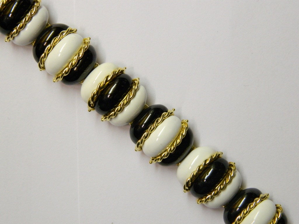 A sophisticated bracelet, manufactured in Italy in the early 1970s, with decorative interlinked 18kt yellow gold elements, on which very fine black and white enamel is applied.