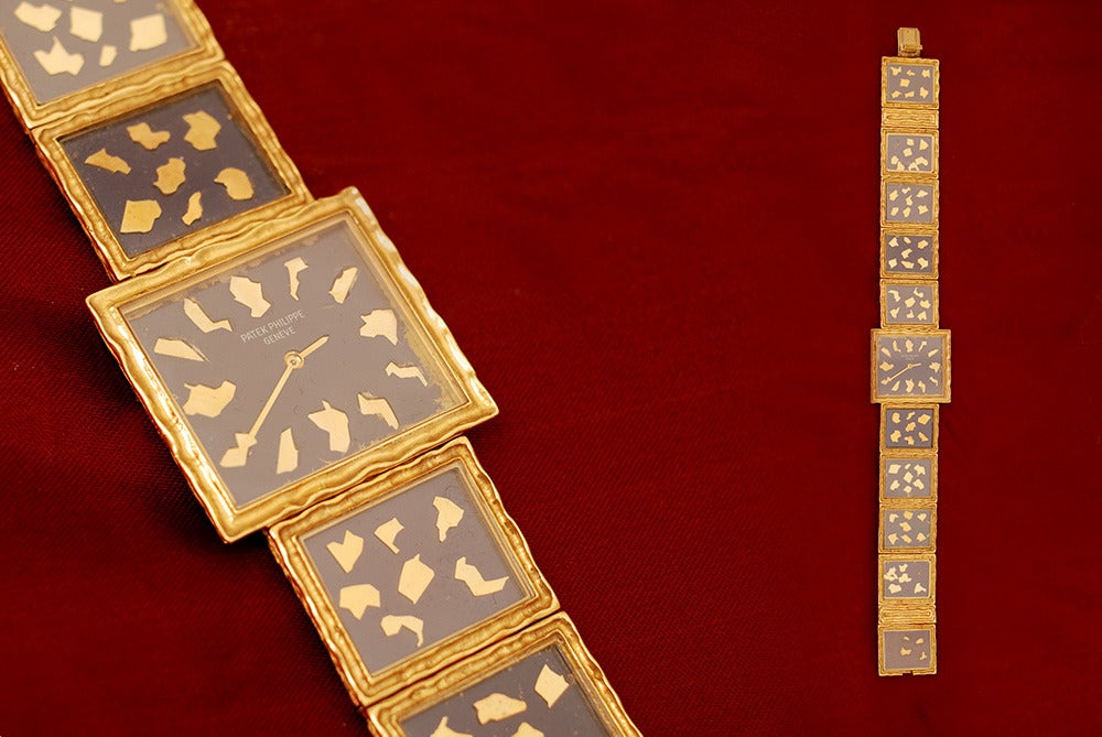 An extremely rare Patek Philippe lady's bracelet watch, manufactured in 1973, constituted of 18k yellow gold square elements with internal blue enamel and applied gold decorations.