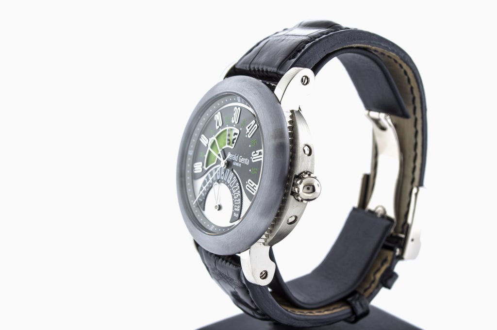 Gerald Genta 18k white gold and tantalum jump hour wristwatch with crocodile strap, deployant buckle, open back.

The small window just above the center of the dial is the hour. The large white hand shows the minutes past the hour on the top arc.