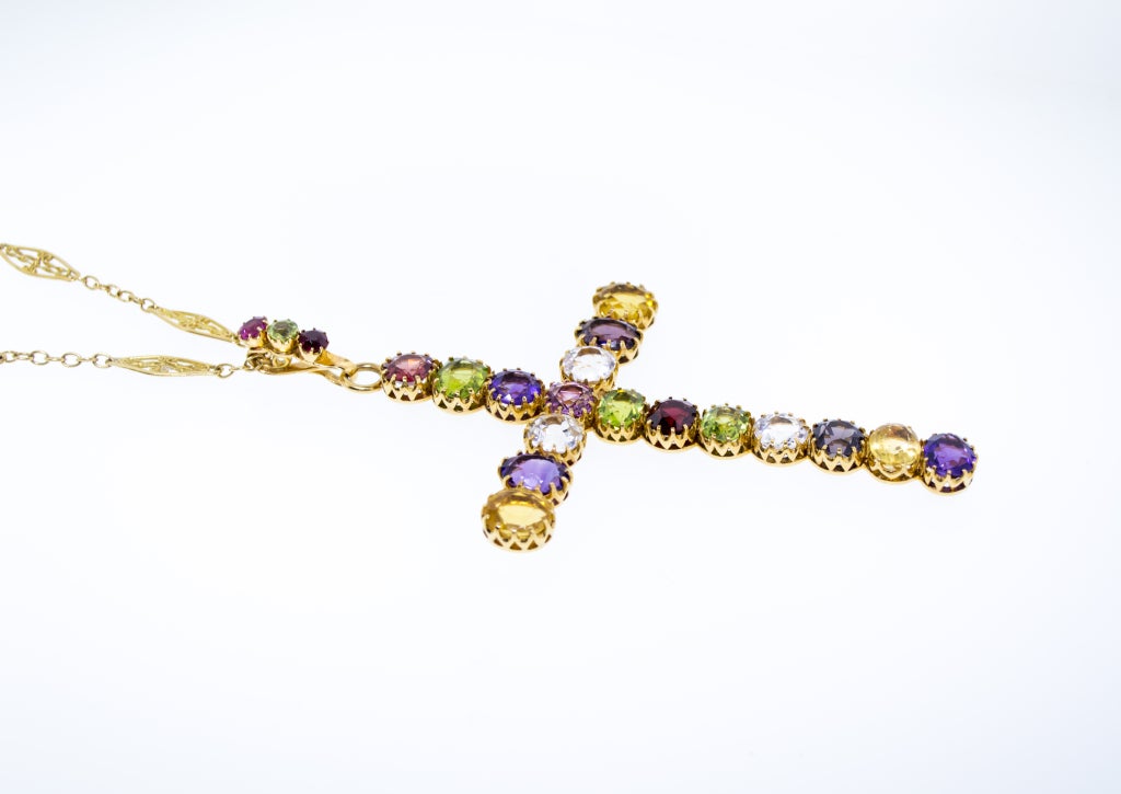 The 18K Gold piece circa 1890.  43 Carats of Natural Colored Gemstones including Spinel, Garnet, Amethyst, Topaz, Citrine and Peridot.  Crosses of this size and with only Colored Gemstones are very rare.  The 18K Gold Chain is 46 inches and from