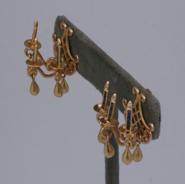 Charming and unusual 14K retro earrings in the form of candle sconces set with baguette sapphires and diamond flamed tips. Sconces are often considered jewelry for the room, here they are decoration for your ears.
Small golden drops replicate the