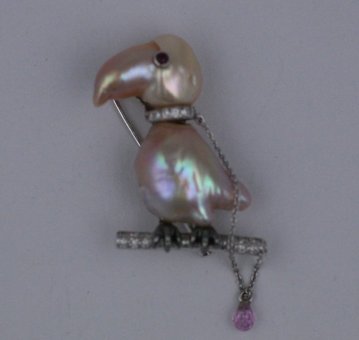 Adorable toucan brooch of naturally formed pearls with diamond pave collar and branch. A tiny pink briolette hangs from his leash and mirrors the pink overtones of the pearl head and body. Set in 18K gold with french touchmarks.  France 1990's.
1