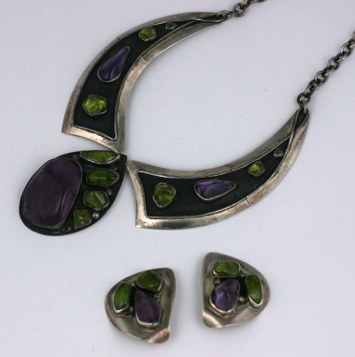 H. Fred Skaggs necklace suite with clip earrings. Tumbled peridot and amythest bezel set stones are highlighted in the patinaed silver areas. Strong design from this American Modernist. 1960's USA. 
Excellent condition.