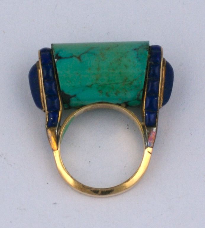 Wonderful, large Art Deco Lapis and Turquoise Cocktail Ring from the late 1930's. A large toggle shaped natural matrix turquoise is set into calibre cut lapis lazuli shoulders with a large cabochon lapis pear shaped stone at each terminal. 
The high