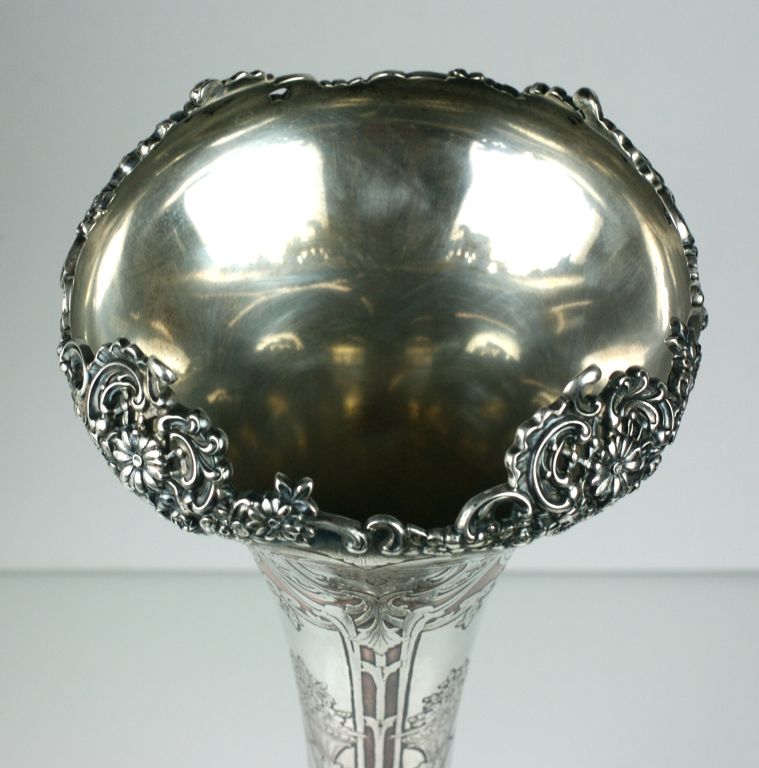 Late Victorian sterling vase by Tiffany & Co. The body of this sterling vase has been overlaid in copper upon which another layer of silver has been added.

4 ornate etched floriform panels surround the body of the vase and extend upwards in baroque