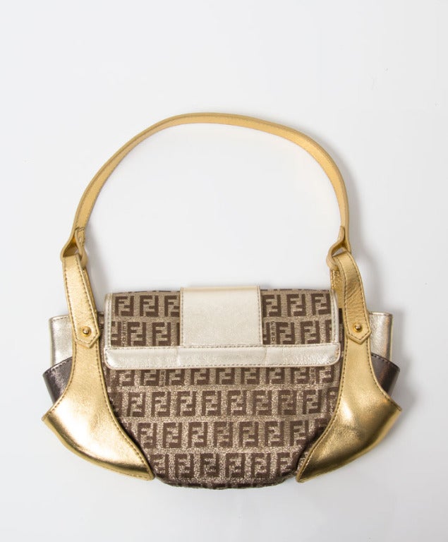 Add a pop of vibrant metallic to your LBD with this fabulous Fendi compilation handbag. Crafted from soft leather in shades of gold, bronze & fendi's zucca material. The bag secures with a clasp fastening.
