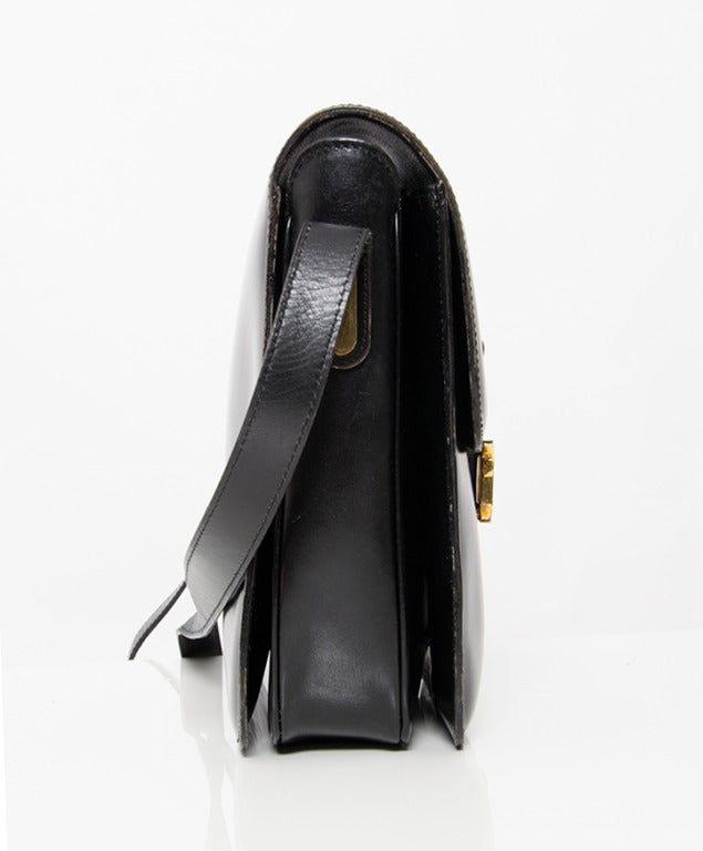 Elégant et discret sac Delvaux en cuir noir avec des détails en or. 
L'intérieur est très spacieux : 3 compartiments séparés:: le central a une poche à fermeture éclair avec un miroir assorti. Livré avec un miroir de poche.