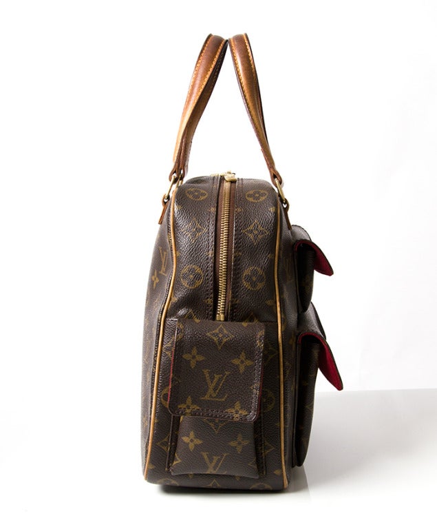 Brown and tan monogram, three exterior snap pockets, one interior pouch pocket and zip closure.