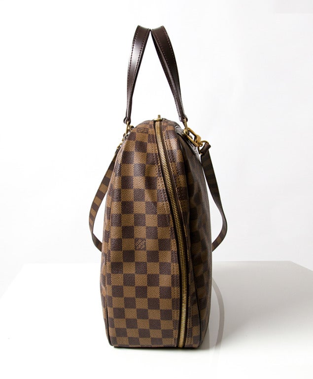 LV Monogram Sac Excursion Shoe Bag. This travel bag is a complement to the Louis Vuitton Monogram luggage set and is designed for carrying shoes with a chic and smart look. 
It has polished brass handle rings and a 3/4 brass wrap around double