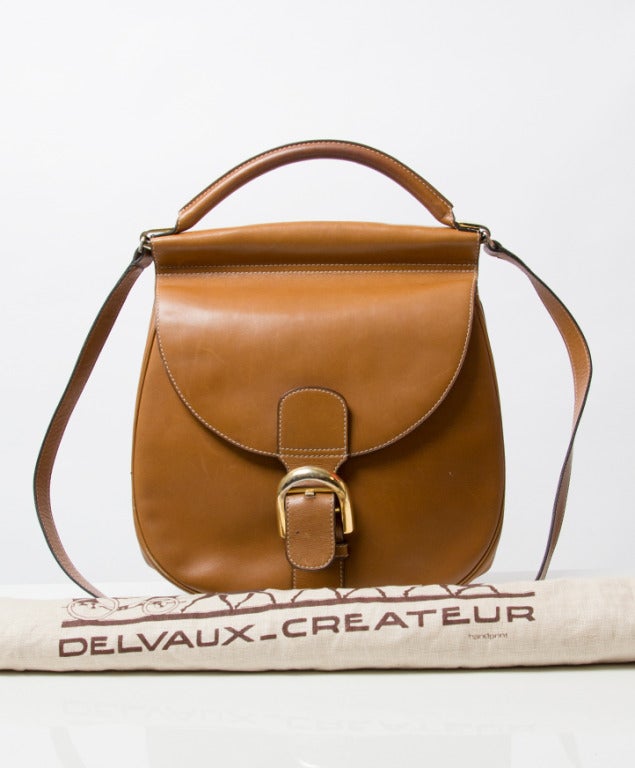 A vintage Delvaux handbag with shoulder strap. 
Cognac colored smooth leather body, gold plated hardware. 
Signature 'Brillant' buckle. 

Comes with pocket mirror and dustbag.