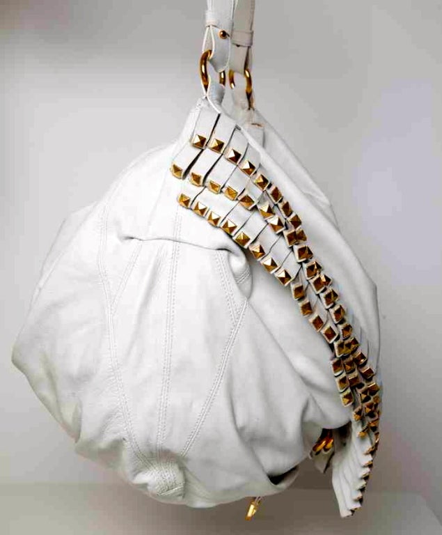 Downsize your day-off bag with Roberto Cavalli's fashionably leather style. 
Embellished with long fringe and gold tone details this accessory is a kick of bohemian chic, complement it with simple pants and multi-strap sandals.