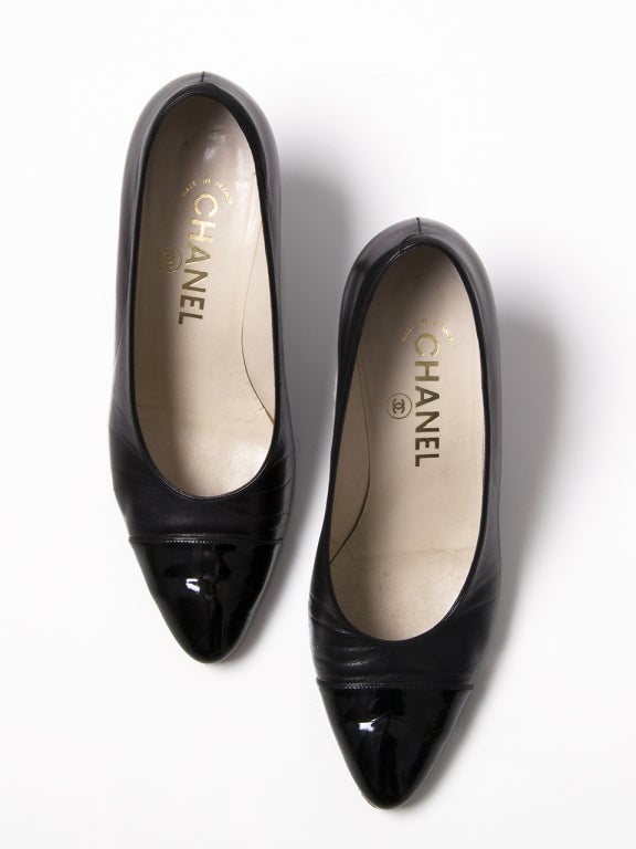 Black Chanel Pumps featuring patent tips.