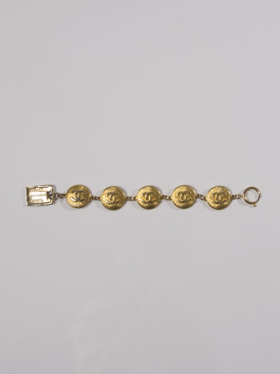Chanel Gold Logo Bracelet featuring 5 round logo shackles and a tablet closing piece with engraved Chanel address. 

total lenght: 23,5cm 
max wearable: 20cm
