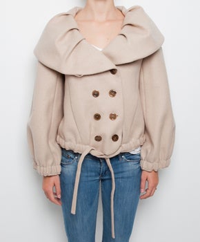 Ruffed wool-till beige jacket that will serve excellently as a cold weather cover-up for a luxurious outdoor look. 
Button fastenings at double-breasted front with oversized round collar.