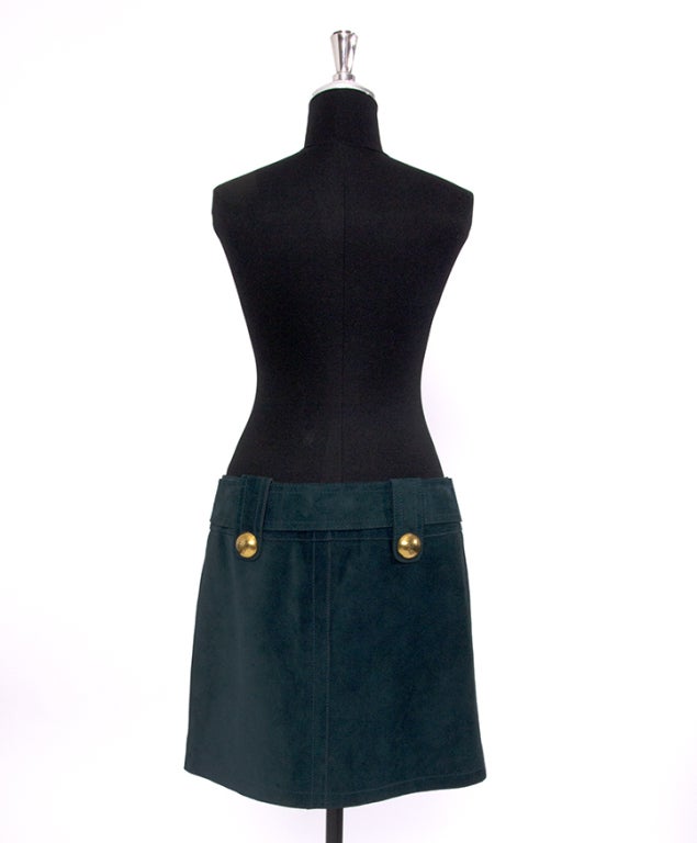 Moss-green suede mini skirt by Gucci. Adjustable belt that gives more volume and large gold tone hardware press buttons. The gold and moss-green are a true match. Wear with dark opaque tights and ankle boots for a chic fall/winter ensemble. 100%