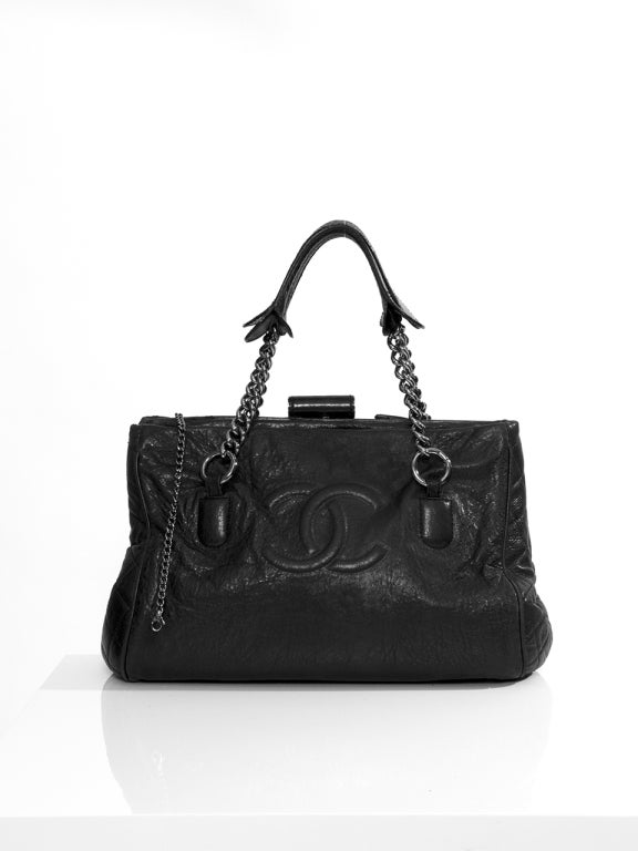 A rare vintage Chanel Doctor Hand Bag Washed Leather Black with large Chanel logo embossed on front and matelassé or quilted stitching on the sides. 

Quilted nylon lining.

Palladium chain.

Can be worn on shoulder or carry in
