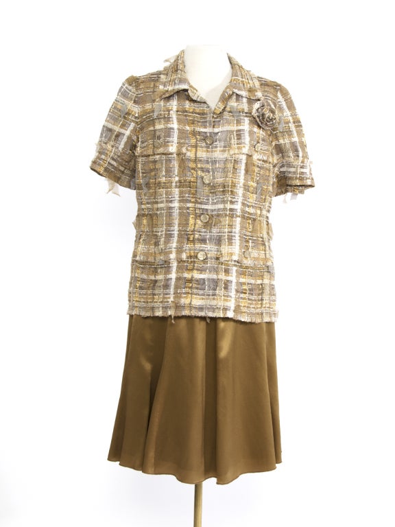 Champagne color tailleur from Chanel. The knee-length skirt is made of 100% silk as well as the double lining. It has a concealed zipper on the back and is beautifully tailored. 
The top can be worn buttoned up as a blouse or unbuttoned as a short