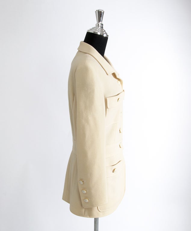 Authentic Chanel blazer made from 100% wool with a 100% silk lining. 
The color is somewhere between a pinkish cream or a ultra soft salmon beige. 
The label states: color 00 

The jacket comes with matching wool skirt making it a deux pièce