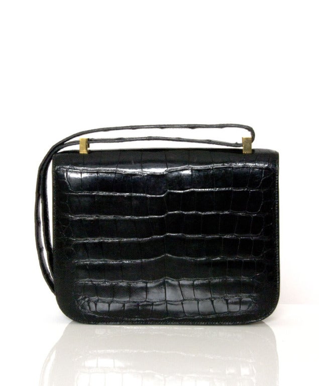 This authentic Hermes Black Porosus Crocodile Constance bag is in excellent condition. This crocodile version is especially rare due the exotic nature of this particular skin. 
 
The Constance has simple clean lines and brings to mind an