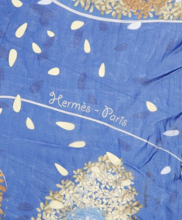 Oriental printed transparent silk scarf in blue and gold. Printed with ortiental drawings of flowers and flower petals.