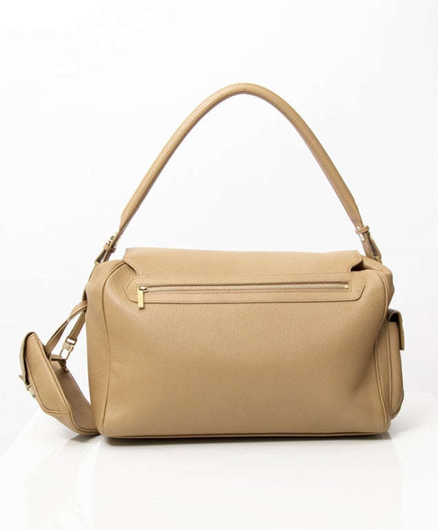 Delvaux carry-all shoulder bag made from grained calfskin in camel hue. Brushed gold hardware throughout. Features smaller clip-on pouch. 

15