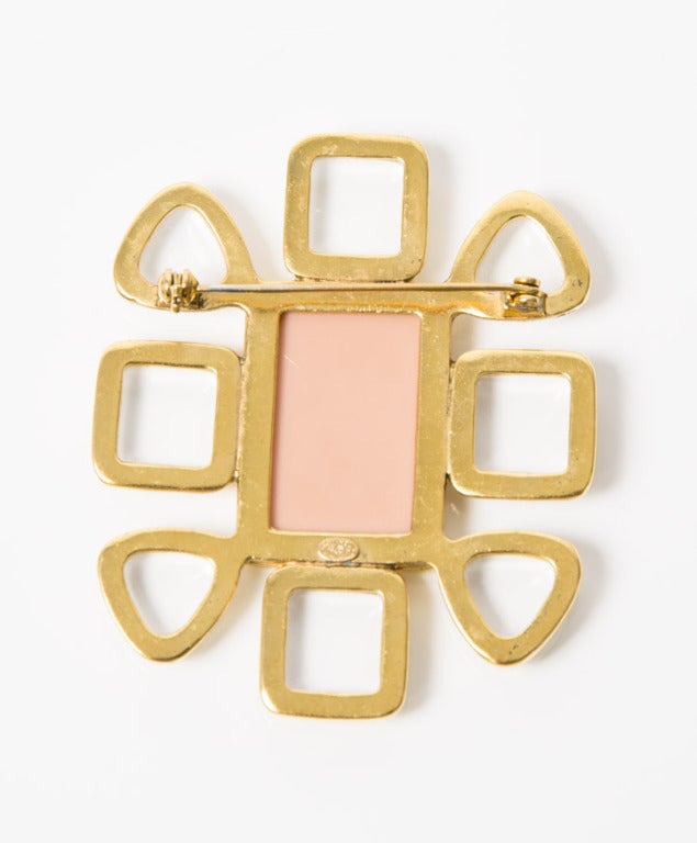 Chanel golden and soft pink brooch with glass work and the CC logo in the middle of the brooch.