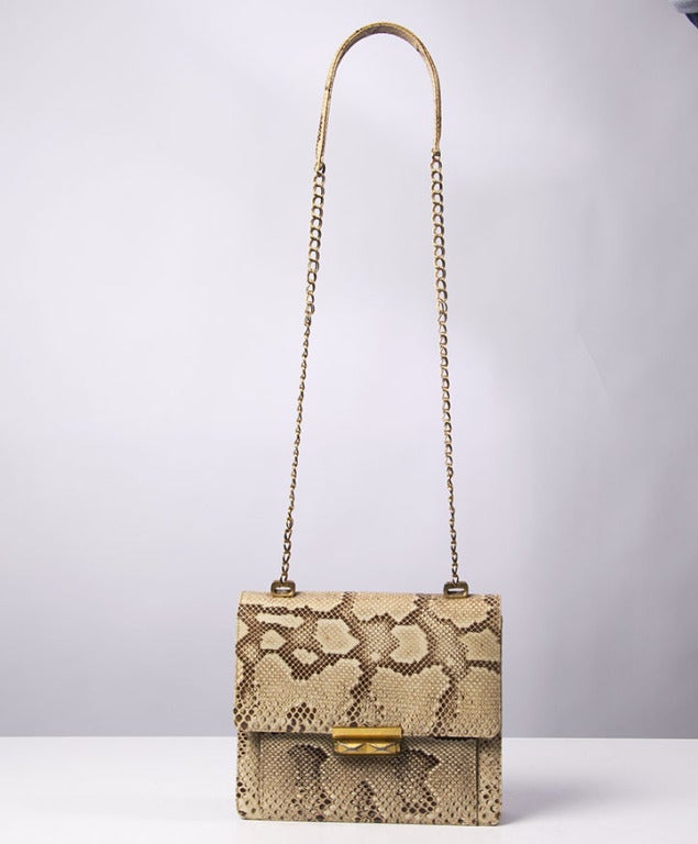 This vintage snakeskin handbag comes with gold hardware chain strap and closing.